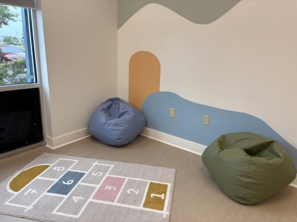 A quiet corner at Crossroads ABA Center with bean bag seating, a number floor mat and natural light from a large window